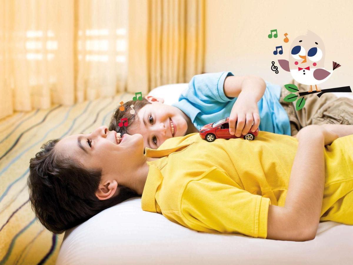 Movenpick Jumeirah Village Triangle Dubái Exterior foto A child with autism playing with a toy car